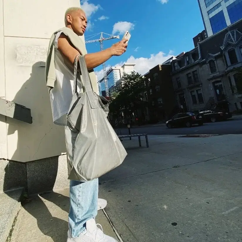 Man standing on sidewalk and looking at his cell phone